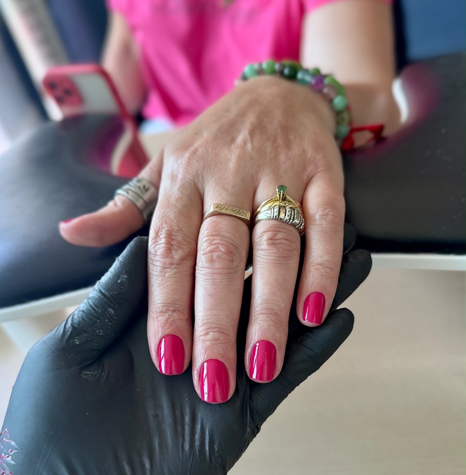 Vibrant pink shellac manicure on short natural nails, finished with black nitrile glove by STTUDIO BL